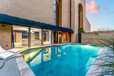 Well-lit private pool surrounded by brick walls. L