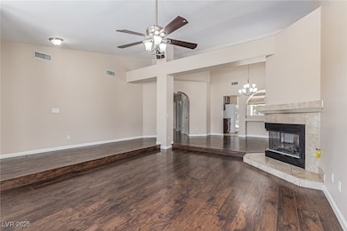 Unfurnished living room with arched walkways, a ce