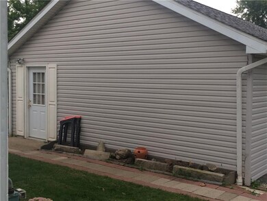 side view of garage w/ sidewalk leading to back do