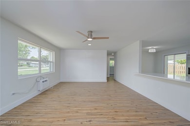 Empty room with light wood finished floors, a wall