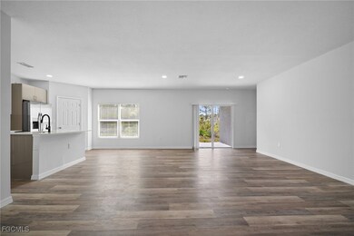 Unfurnished living room with dark wood-type flooring and recessed lighting