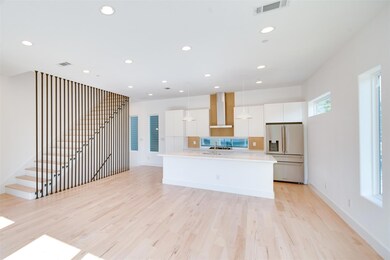 Kitchen with wall chimney range hood, an island wi