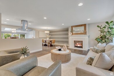 Living room featuring recessed lighting, light wood-style floors, and a fireplace with flush hearth