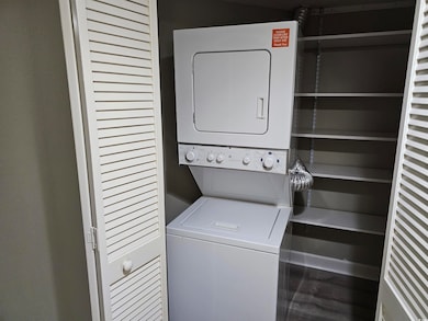 Washroom featuring stacked washer and dryer and la