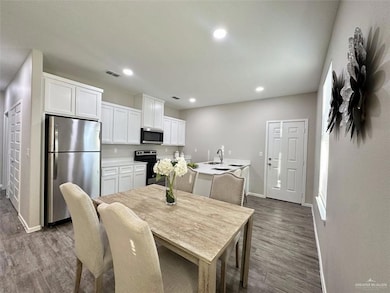 Dining space with dark wood-type flooring and recessed lighting