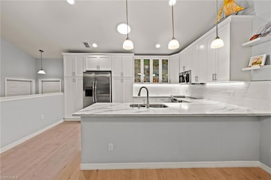Kitchen featuring white cabinets, sink, light wood