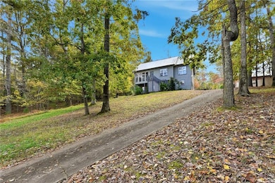 View of front of home featuring a front lawn, stairway, and a metal roof