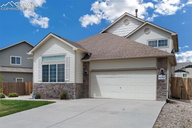 View of front of home featuring stone siding, a garage, driveway, roof with shingles, and fence