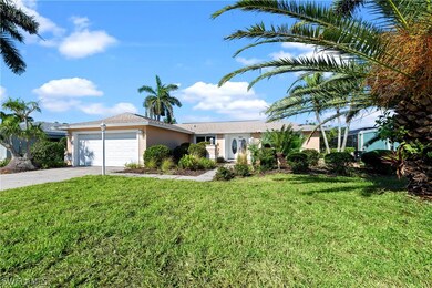 Single story home with a garage and a front lawn