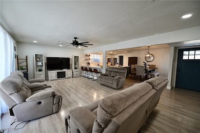 Living room with plenty of natural light, recessed lighting, wood finished floors, a textured ceiling, and a ceiling fan