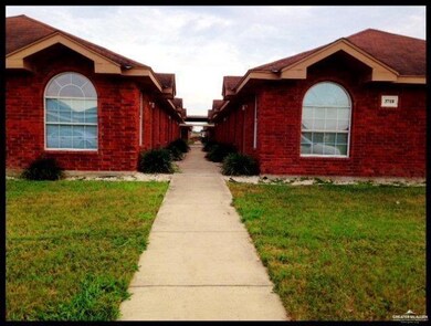 View of side of property with a yard and brick siding