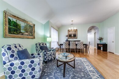 Sitting room with wood-type flooring, a chandelier