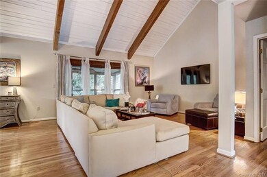 Open concept living room with wood beams and high 