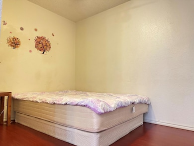 Bedroom with a textured ceiling and dark wood-type
