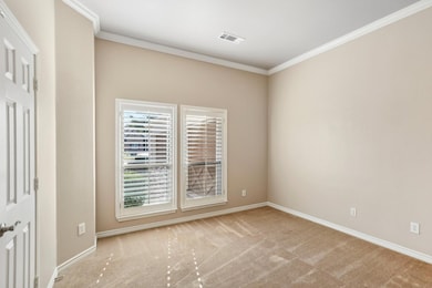 Carpeted empty room featuring ornamental molding