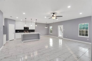 Kitchen with backsplash, ceiling fan, stainless st