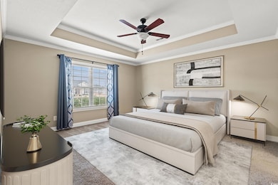 Carpeted bedroom featuring a tray ceiling, ceiling