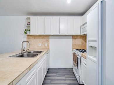 Kitchen featuring white appliances, light counter