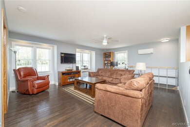 Hardwood floored living room featuring a wall unit