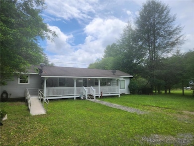 Back of property with a yard and a porch