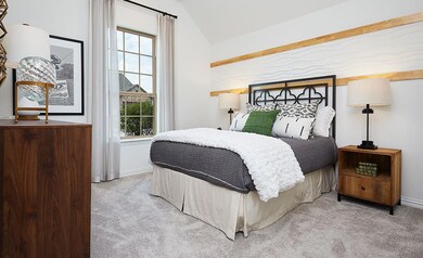 Bedroom with lofted ceiling, multiple windows, an