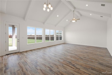 Unfurnished living room with beamed ceiling, healthy amount of natural light, wood finished floors, recessed lighting, and a chandelier