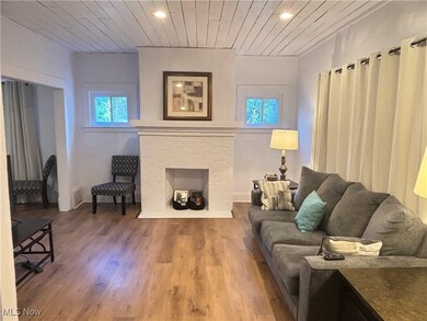 Living room with wood ceiling, hardwood / wood-style floors, and a fireplace