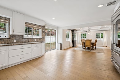 Kitchen with recessed lighting, ornamental molding, white cabinets, backsplash, and coffered ceiling
