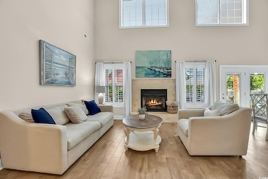 Living room with a warm lit fireplace, wood finish