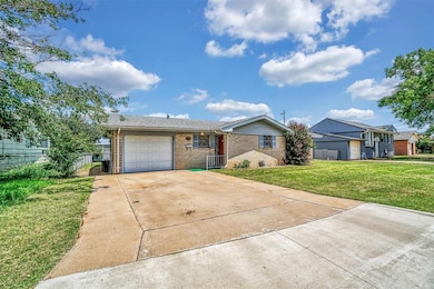 Single story home with brick siding, a garage, and driveway