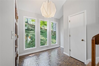 Light filled windowed entry with updated lighting and recessed alcove for entry table.