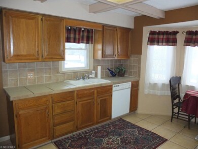 Kitchen has ceramic tile flooring and backsplash.