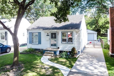 View of front facade featuring a shingled roof, an outdoor structure, a garage, and a gate