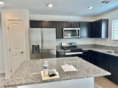 Kitchen with stainless steel appliances, light woo