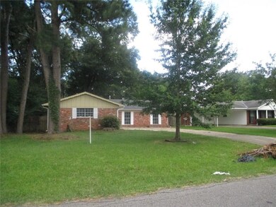 Large front yard with tall pine trees