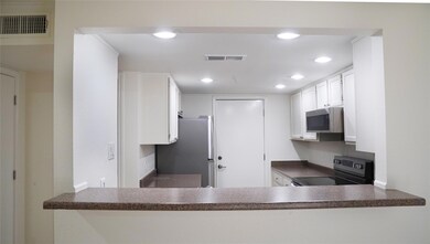 Kitchen featuring white cabinets, stainless steel 