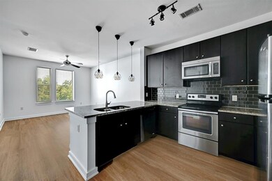 Kitchen with a peninsula, a sink, visible vents, 