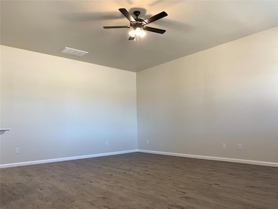 Unfurnished room featuring dark wood finished floors and a ceiling fan