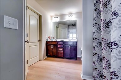 Full bathroom with baseboards, curtained shower, v