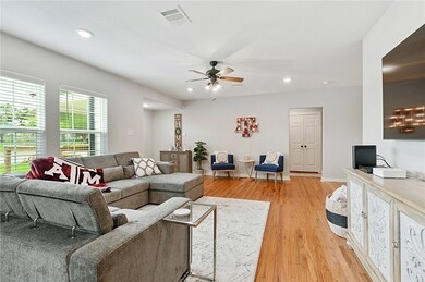 Living room with ceiling fan and hardwood / wood-s