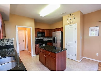 Open concept kitchen w/ granite counters, tile bac