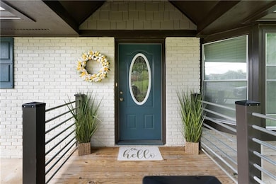 Entrance to property featuring brick siding and covered porch