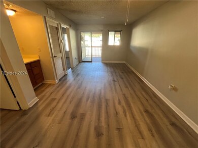 Empty room with a textured ceiling and wood-type f