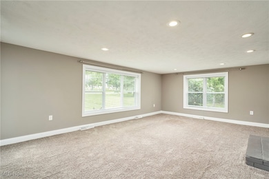 Empty room with recessed lighting, plenty of natural light, and light colored carpet