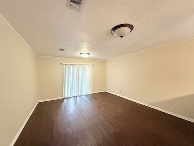 Spare room featuring a textured ceiling, dark wood