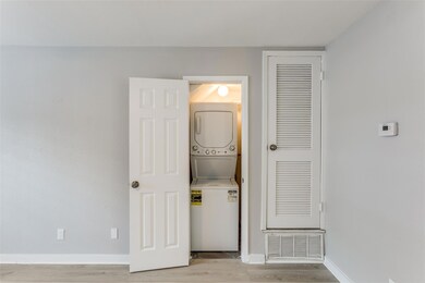 Laundry room featuring stacked washing machine an
