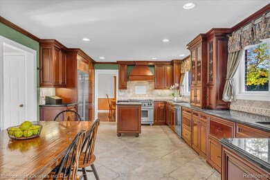 Kitchen with premium appliances, backsplash, recessed lighting, dark stone countertops, and custom exhaust hood