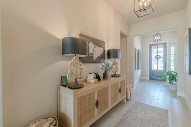 Foyer featuring a chandelier and light wood-style