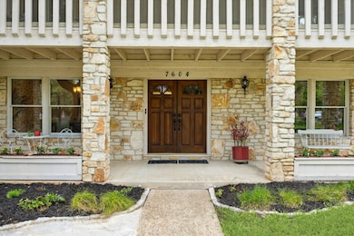 Entrance to property with stone siding and a porch