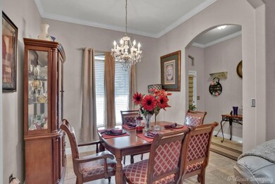 Tiled dining room featuring crown molding and a ch